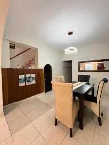 a dining room with a black table and chairs at CIX HOUSE, Casa completa de 3 pisos in Chiclayo