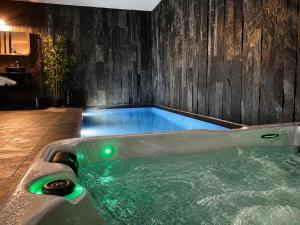 a jacuzzi tub in the middle of a room at Wellness queen in Harzé