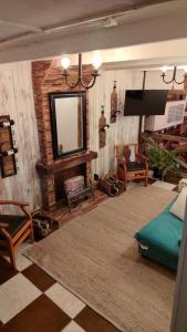 a living room with a flat screen tv and a couch at Hostal Posada Lupinos in Punta Arenas
