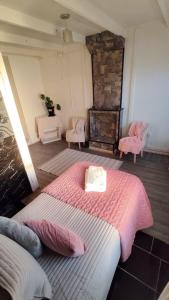 a bedroom with a large bed with a pink blanket at Hostal Posada Lupinos in Punta Arenas