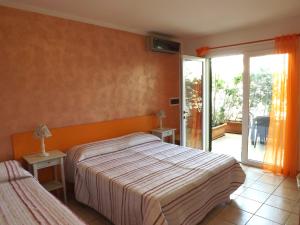 トッレ・サン・ジョヴァンニ・ウジェントにあるAraucariaのベッドルーム1室(ベッド2台付)、スライド式ガラスドアが備わります。