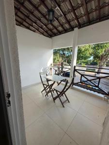 a patio with two chairs and a table on a porch at Pousada Pérola do Mar in Tamandaré