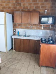 a kitchen with a sink and a stove and a microwave at Casa 2 dormitorios B in Villa Guntz