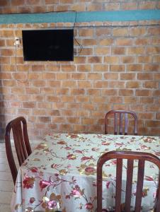 a table with a floral table cloth on it with a tv at Casa 2 dormitorios B in Villa Guntz