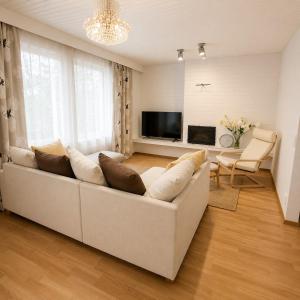 a living room with a white couch and a television at Nordic City Home in Lahti