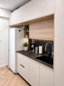a white kitchen with a sink and a refrigerator at סוויטת נווה in Pardes H̱anna