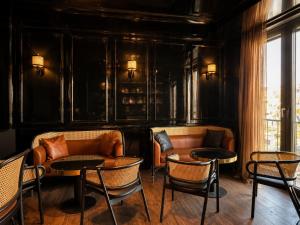 a room with couches and tables and chairs at Lusso Hotel in Prishtinë