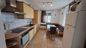a kitchen with white appliances and a table in it at Mecseki Farkasvár in Magyarhertelend +17 photos