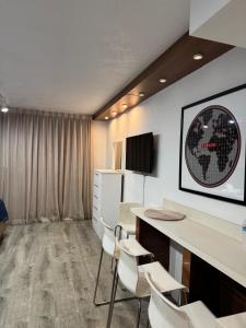 a room with a desk and chairs and a tv at Renovated Beachfront Condo with Balcony in Sunny Isles Beach