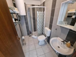 a bathroom with a shower and a toilet and a sink at Villa Kanata in Povile +46 photos