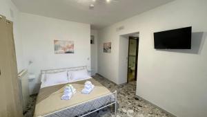 a bedroom with a bed and a flat screen tv at La casa di Carmela e Francesco b&b in Massa