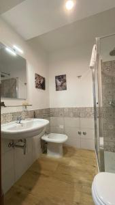 a bathroom with a sink and a toilet and a mirror at La casa di Carmela e Francesco b&b in Massa