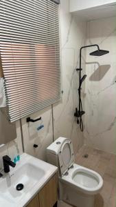 a bathroom with a white toilet and a sink at Sweet Sbah in Hail