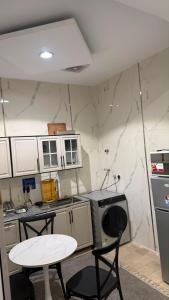 a kitchen with two chairs and a table and a stove at Sweet Sbah in Hail +1 photo