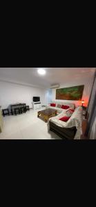 a living room with a bed and a table at rahamni stays in Cheraga +2 photos