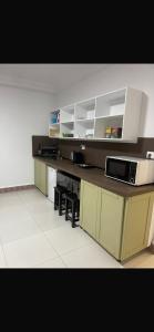 a kitchen with a counter top with a microwave at rahamni stays in Cheraga