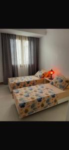 a bedroom with three beds and a lamp on a table at rahamni stays in Cheraga