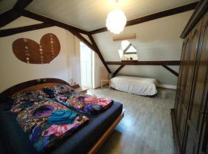 a bedroom with a bed in a attic at BnB LES OISEAUX, chez Lidia, 26m2 à 44m2, 2ème étage in Vendlincourt +34 photos