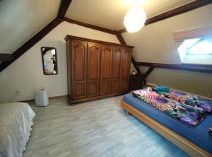 a bedroom with a bed and a wooden cabinet at BnB LES OISEAUX, chez Lidia, 26m2 à 44m2, 2ème étage in Vendlincourt