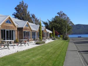 una fila de cabañas a orillas de un lago en Lakefront Lodge en Te Anau