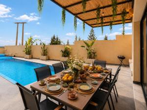a table with food and fruit on a patio with a pool at Villa Oumnass, Marrakech in Oumnas