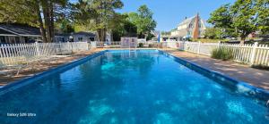 a large blue swimming pool with a white fence at The Tallwood Motel in Wells