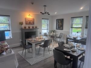 a dining room with tables and chairs and a fireplace at Daviot Lodge in Inverness