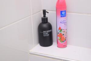 a black bottle of shampoo next to a pinkitizer at Soft stay homes in Mombasa