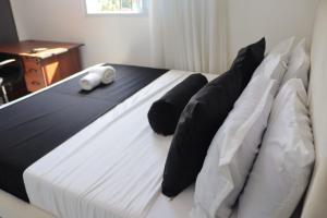 a bed with black and white pillows on it at Soft stay homes in Mombasa