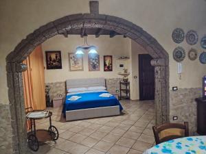 a bedroom with a blue bed in a stone wall at La perla del mare in Santa Flavia