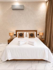 a bedroom with a white bed with towels on it at Villa Oumnass, Marrakech in Oumnas +17 photos