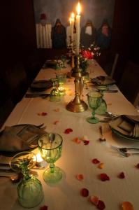 einen langen Tisch mit einer Kerze und Blumen darauf in der Unterkunft Riad Les Hibiscus in Marrakesch