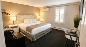 a hotel room with a large bed and a desk at Pilgrim House in Provincetown +91 photos