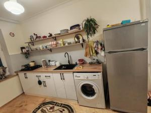 a kitchen with a refrigerator and a washing machine at GreenHouse in Qusar