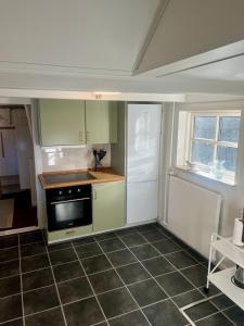 a kitchen with green cabinets and a stove top oven at The Blue Country House in Nørre Broby +12 photos