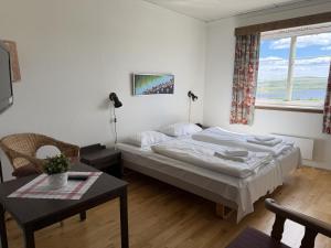 a bedroom with a bed and a table and a window at Torsetlia in Dagali
