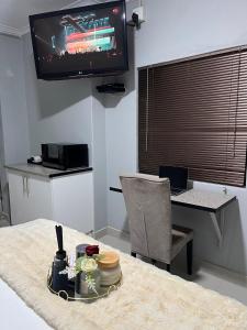 a living room with a table with a television and a table sidx sidx sidx at LINGAS inn in Richards Bay +4 photos
