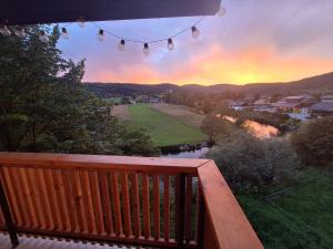 a view of a sunset from the deck of a house at Hiška na skalci, The House on the Rock in Znojile pri Krki