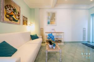 a living room with a white couch and a table at Victory's Luxury House with Jacuzzi on the Roof in Casamicciola Terme