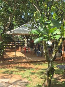a group of people sitting under a tent in a park at Chacara Maua Eventos in Planaltina