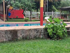a swimming pool in a yard with a playground at Chacara Maua Eventos in Planaltina +1 photo