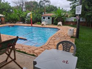 a swimming pool with a table and a chair next to it at Chacara Maua Eventos in Planaltina
