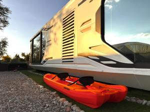 a red kayak is sitting next to a train at Futuristic Capsule - Private Jacuzzi & Beach access in Wapnica +11 photos
