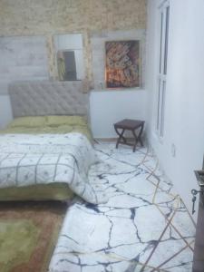 a bedroom with a bed and a table in it at Pieds dans l'Eau Douaouda in Fouka