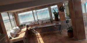 a living room with a couch in front of windows at Pieds dans l'Eau Douaouda in Fouka