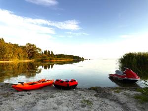 three boats sitting on the shore of a river at Futuristic Capsule - Private Jacuzzi & Beach access in Wapnica