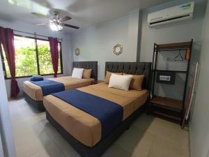 a bedroom with two beds and a ceiling fan at Ballena Rey Hotel in Uvita +108 photos