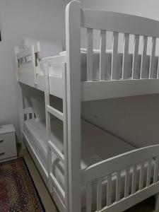a white bunk bed with a white ladder at Casa de Flori in Përmet