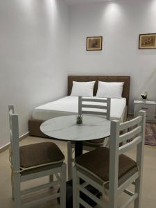 a bedroom with a bed and a table and chairs at Casa de Flori in Përmet