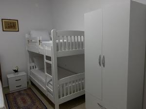 a white childs bunk bed in a room at Casa de Flori in Përmet +9 photos